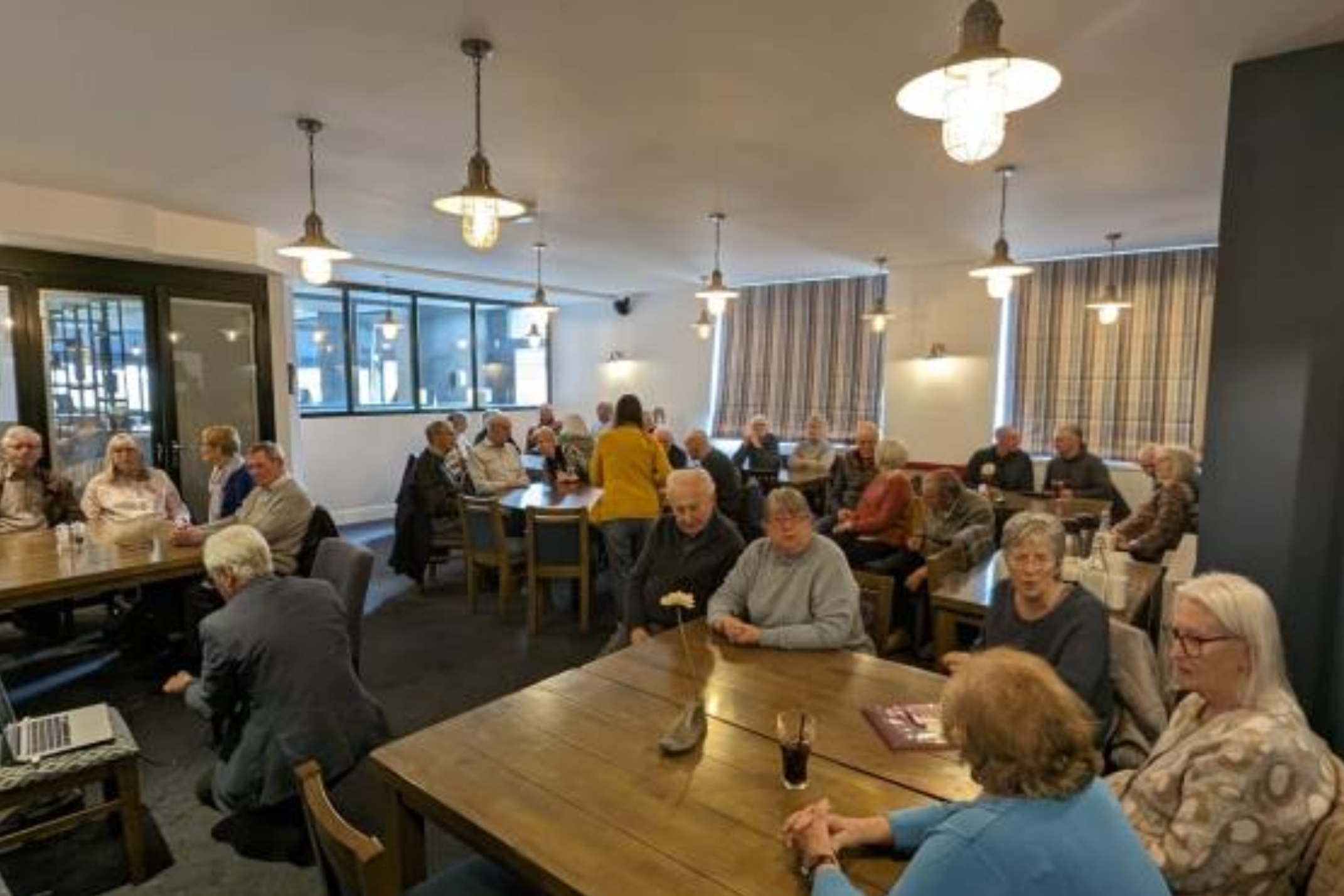 People sat at tables at a monthly meet-up